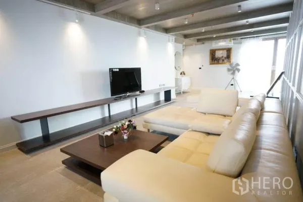 คอนโด ให้เช่าหรือขายในBang Na, Bangkok - ห้องนั่งเล่นกว้าง โซฟาหนังตัวแอล ชั้นวางทีวียาว และไฟสปอตไลต์เพดาน