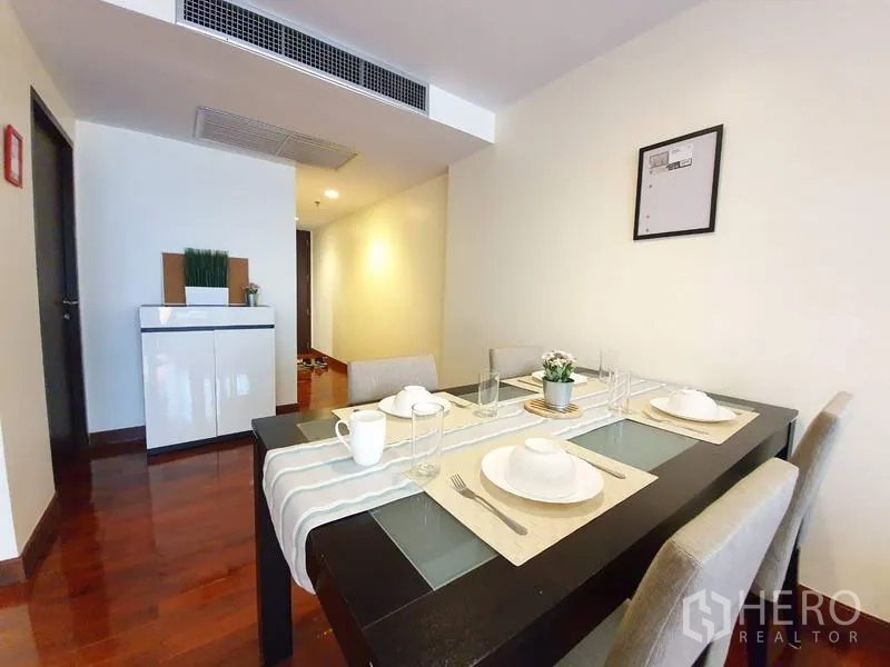 Condominium for rent or sale in Pathum Wan, Bangkok - Dining table set for four beside a hallway with built-in air-conditioning vent.