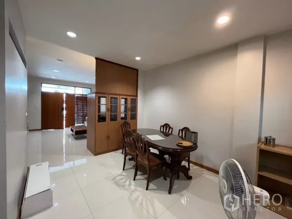 Townhouse for rent in Bang Kho Laem, Bangkok - Dining area with wooden table and built-in cabinet facing the front entry.