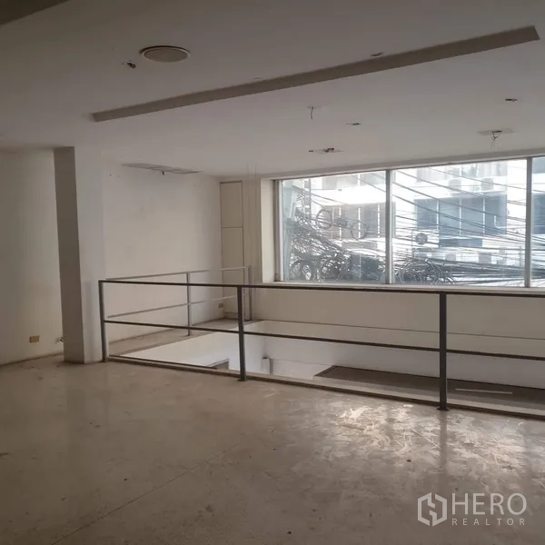 Home Office for rent in Khlong Toei, Bangkok - Upper floor landing with safety railing and large street-facing window.