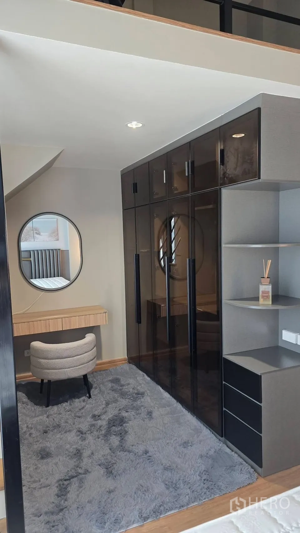 Townhouse for rent in Bang Phli, Samut Prakan - Dressing area with round mirror, vanity desk, and smoked-glass wardrobes.