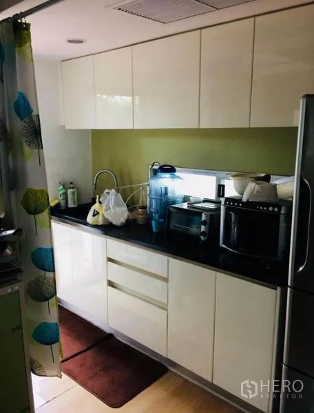 บ้าน ขายในPhra Khanong, Bangkok - ครัวบิวท์อินสมัยใหม่ ตู้สีขาวเงา เคาน์เตอร์หินสีดำ พร้อมเครื่องใช้ไฟฟ้า