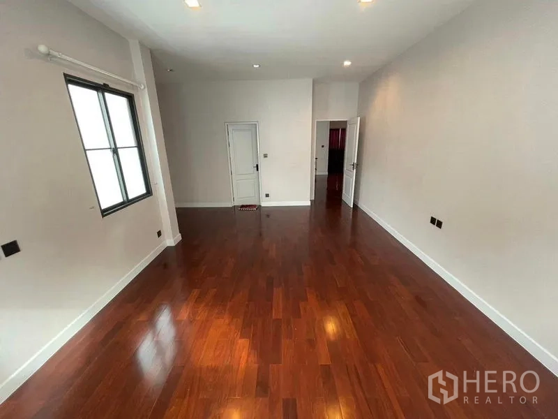 Detached House for sale in Mueang Samut Prakan, Samut Prakan - Upstairs bedroom with wooden floors, white walls and natural light.