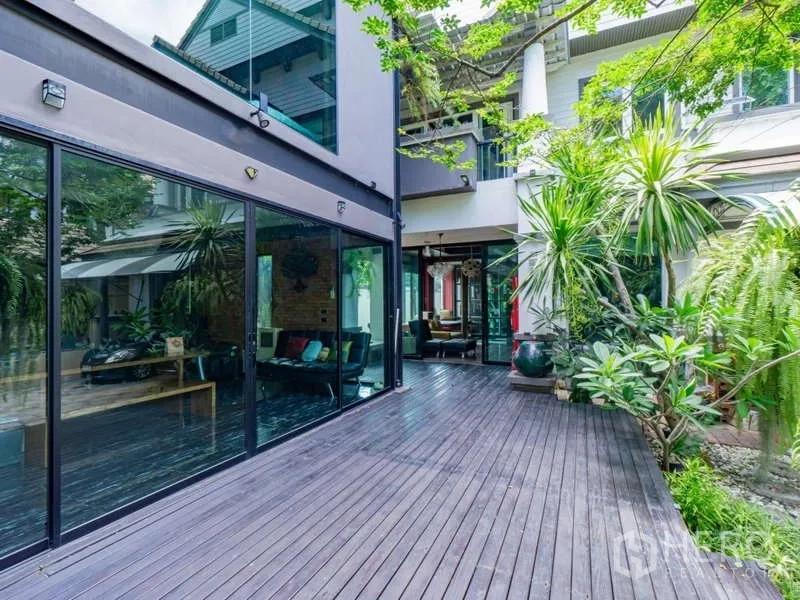 Detached House for sale in Suan Luang, Bangkok - Courtyard with expansive wooden deck and floor-to-ceiling glass walls.