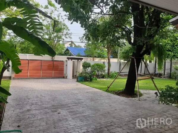 独立式住宅 出租在Bang Kapi, Bangkok - 宽阔的铺装车道、推拉大门与成熟花园