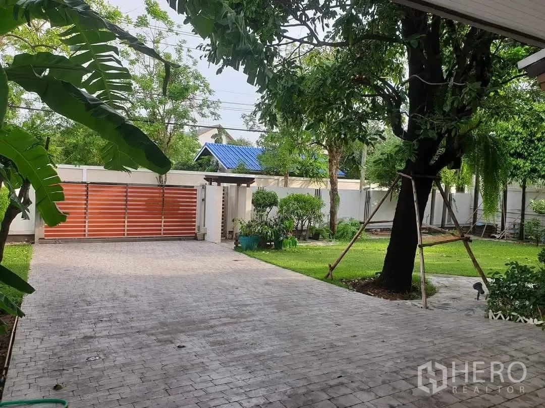 独立式住宅 出租在Bang Kapi, Bangkok - 宽阔的铺装车道、推拉大门与成熟花园