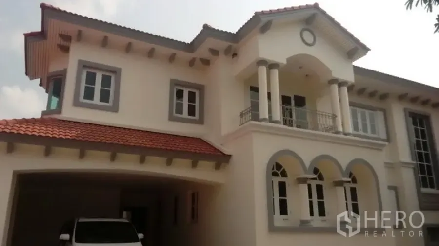 บ้าน ขายในBueng Kum, Bangkok - ด้านหน้าบ้านเดี่ยวสองชั้นหลังคากระเบื้องแดง มีโรงจอดรถ ระเบียง และบานหน้าต่างโค้ง