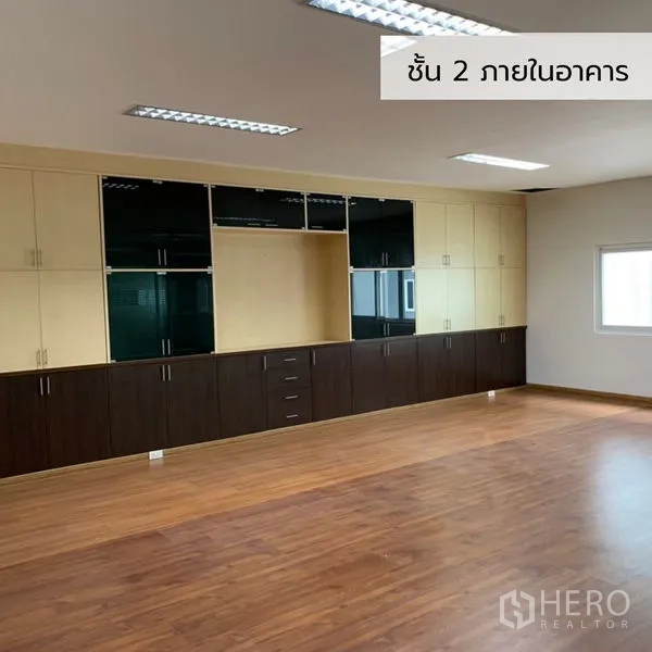 Office Space for rent in Bueng Kum, Bangkok - Large office room with built-in wall cabinets and warm laminate flooring.
