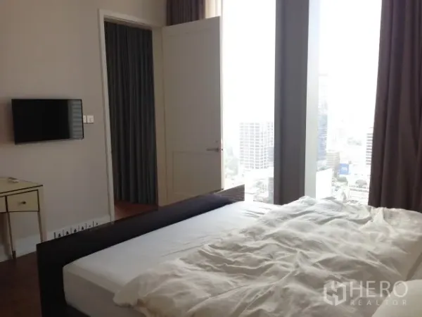 Condominium for rent or sale in Bang Rak, Bangkok - Bedroom with large window and sweeping Bangkok city views from a high floor.