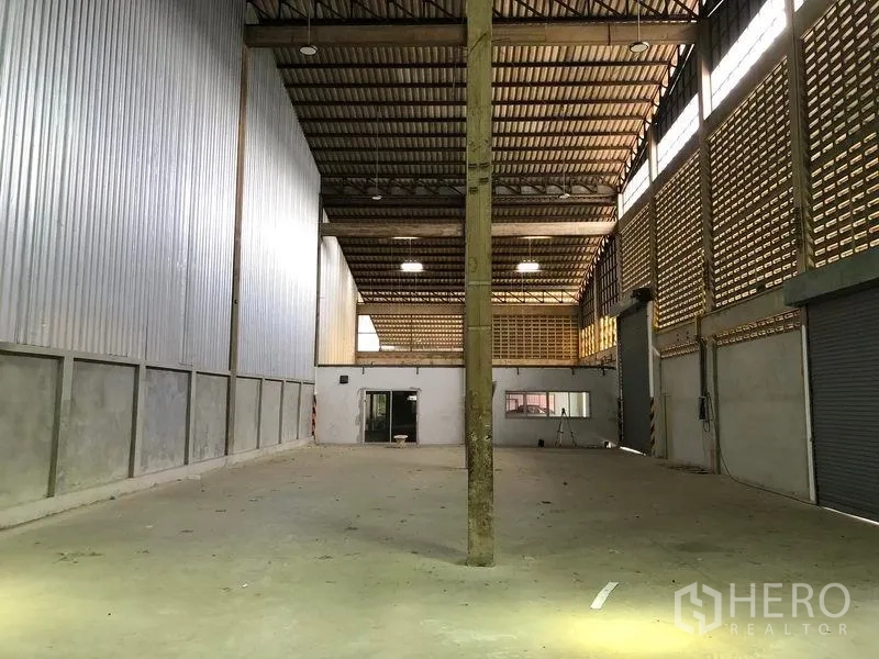 货栈 出租在Pathum Thani - 大型库区，带办公室窗、卷帘门与通风砖墙。