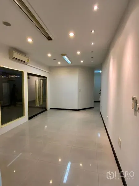 Office Space for rent in Watthana, Bangkok - Bright office interior with recessed lighting, glossy tile floor, air-conditioning, and a glass entry.