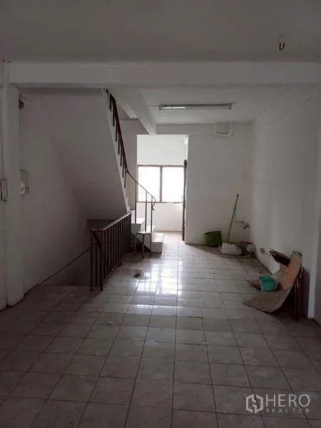 Shophouse for rent in Pom Prap Sattru Phai, Bangkok - Spacious tiled floor plate with staircase, suitable for office or showroom.