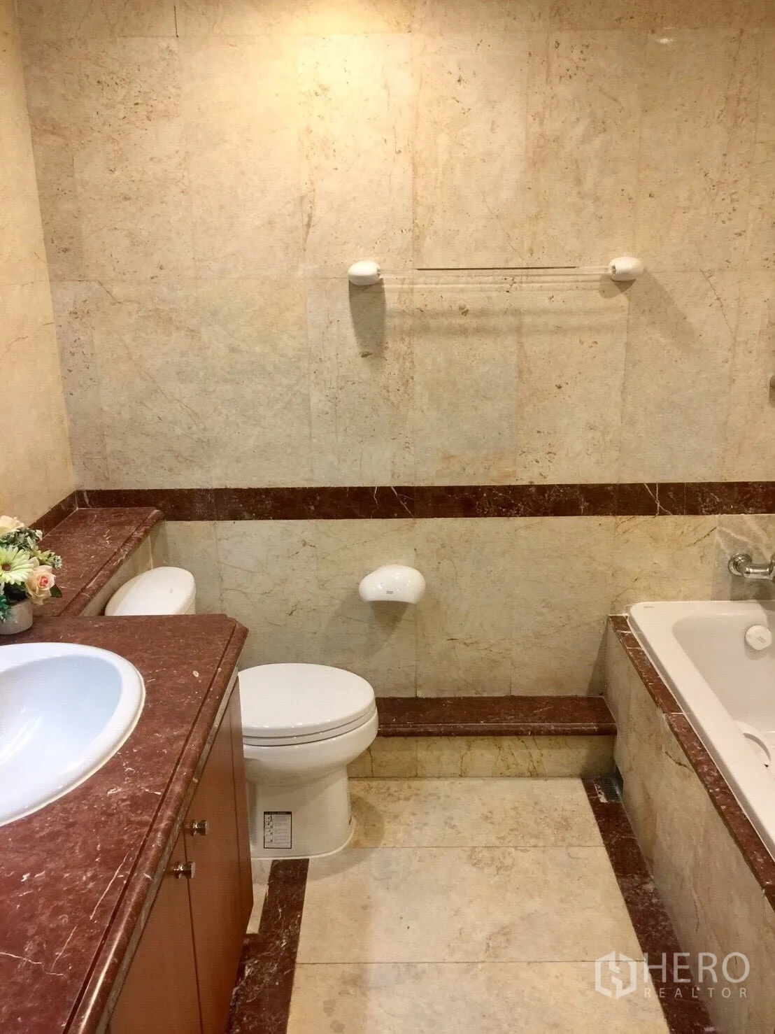 Condominium for rent in Pathum Wan, Bangkok - Marble-tiled bathroom featuring a vanity, toilet and bathtub.