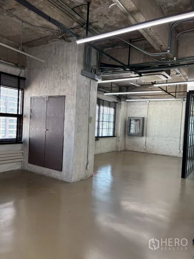 Office Space for rent in Watthana, Bangkok - Long open-plan office with multiple windows, exposed services and polished flooring.