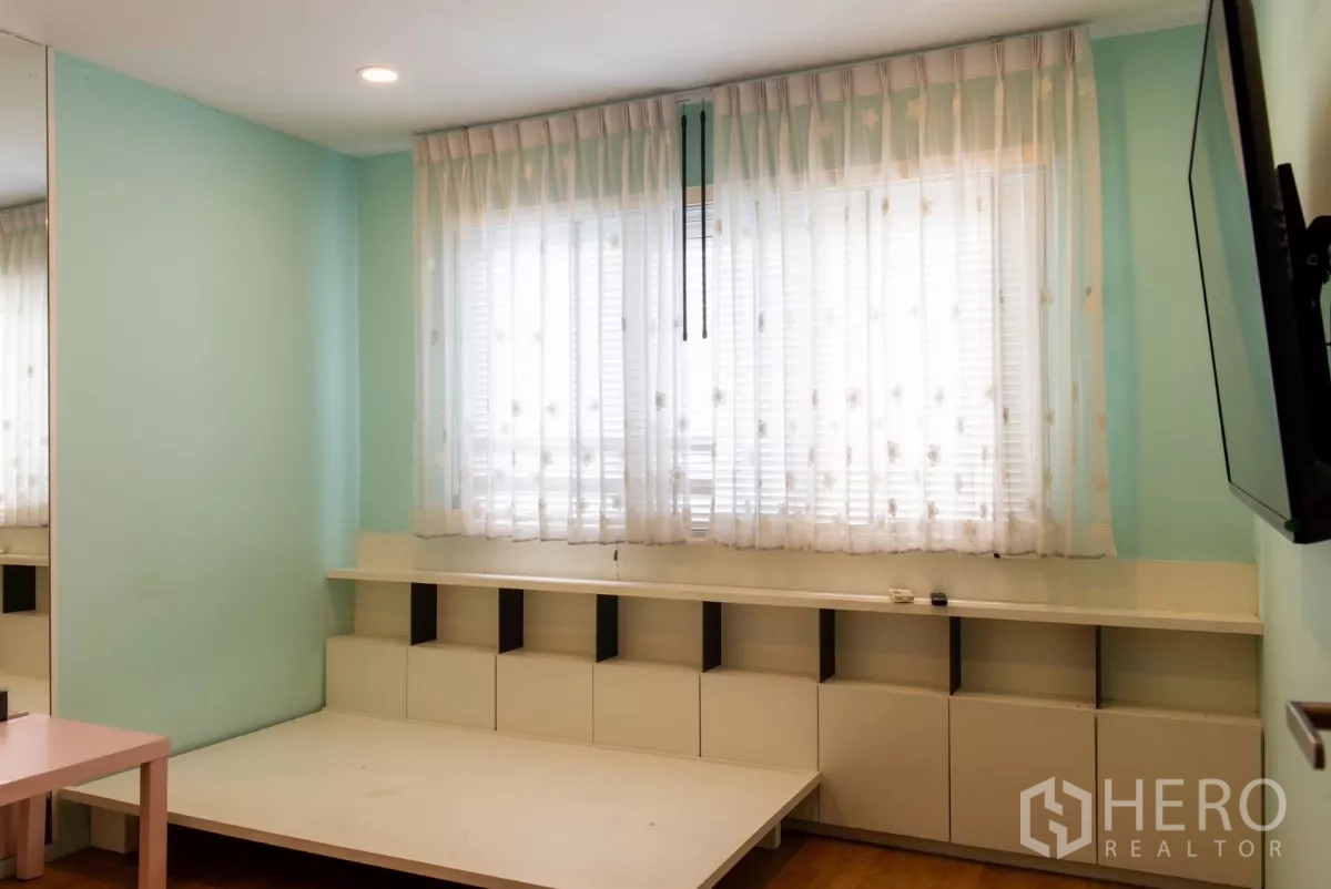 ทาวน์เฮาส์ ให้เช่าในLat Phrao, Bangkok - ห้องนอนสว่างผนังสีเขียวมิ้นท์ ผ้าม่านโปร่งและพื้นยกเตี้ย