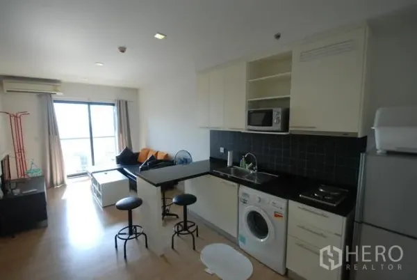 คอนโด ให้เช่าในSathon, Bangkok - ห้องนั่งเล่นแบบเปิด พร้อมครัวบิวท์อิน เคาน์เตอร์บาร์ เครื่องซักผ้า และประตูระเบียงรับแสง