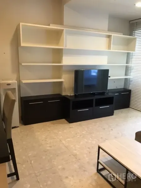 คอนโด ให้เช่าในKhlong Toei, Bangkok - ห้องนั่งเล่นพร้อมชั้นทีวีบิวท์อิน ชั้นวางของสีขาวและมู่ลี่หน้าต่าง