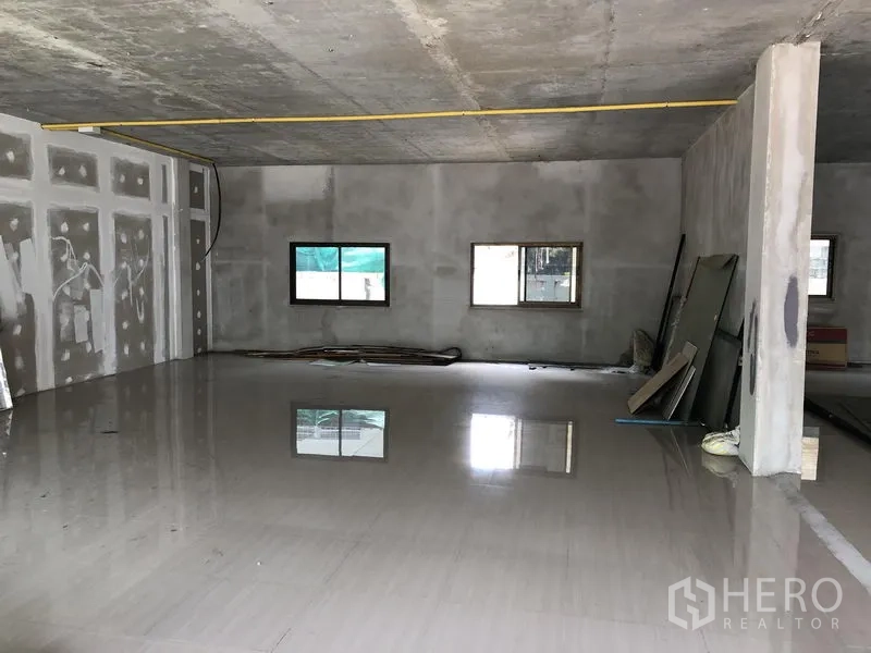 零售空间 出租在Wang Thonglang, Bangkok - 未完成装修的室内，亮面地砖、混凝土墙顶，两扇窗与外露管线，便于定制施工