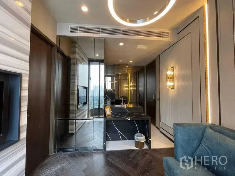 คอนโด ให้เช่าในKhlong Toei, Bangkok - โถงเข้าสู่ห้องนั่งเล่น พื้นไม้ปาร์เกต์ลายก้างปลา ผนังกระจก และเคาน์เตอร์หินอ่อน