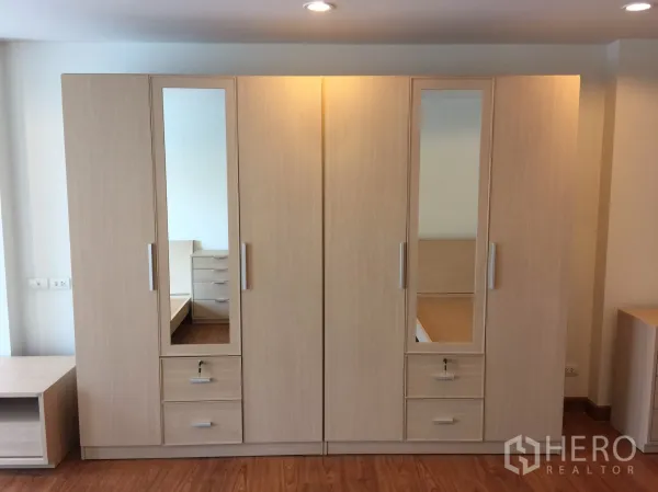 公寓 出租在Bang Rak, Bangkok - 卧室内两组浅木衣柜，带镜面与抽屉