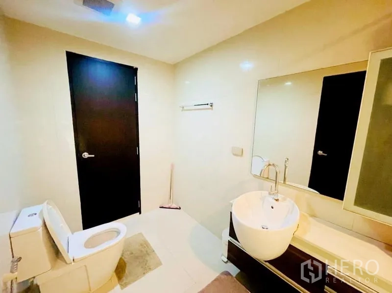 Condominium for rent - Modern bathroom with round vessel sink, large mirror, and toilet.