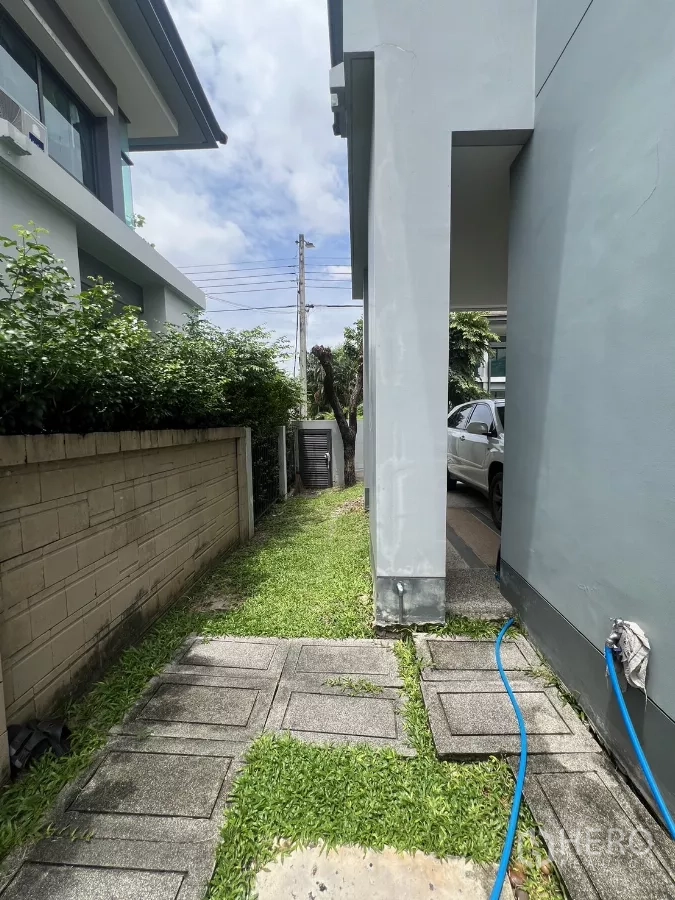 Detached House for rent in Bang Kapi, Bangkok - Paved side path with garden hose leading from backyard to carport.