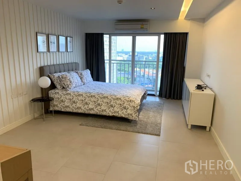 Condominium for rent in Sathon, Bangkok - Bright bedroom with balcony access, tiled floors and city outlook.