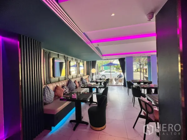 พื้นที่ขายปลีก ให้เช่า - ที่นั่งโซฟายาวพร้อมหมอน ผนังกระจกเงา และกระจกเต็มบานมองเห็นถนน