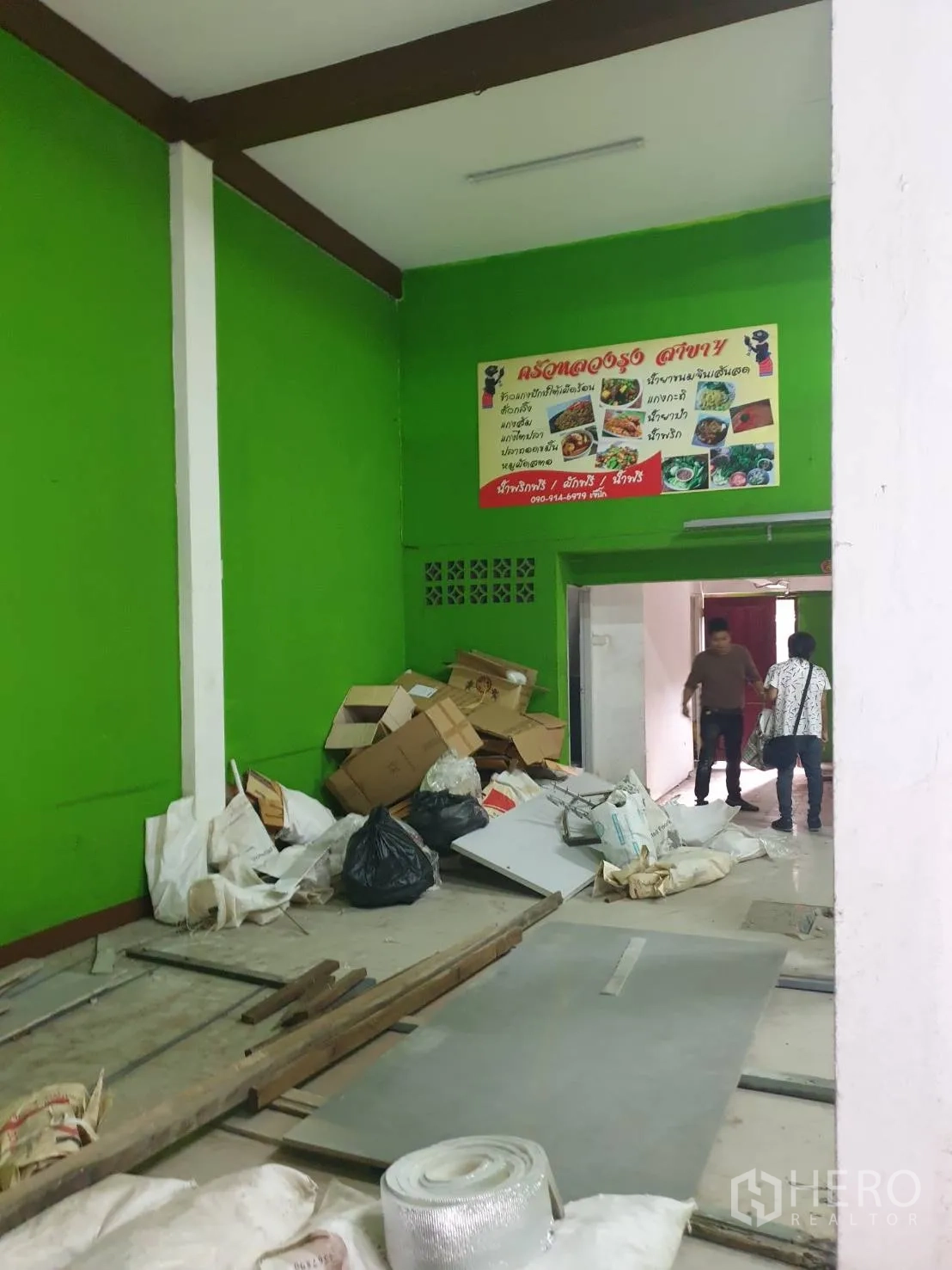 อาคารพาณิชย์ ให้เช่าในPhra Khanong, Bangkok - ภายในชั้นล่างกำลังปรับปรุง ผนังสีเขียวสดและวัสดุก่อสร้างวางอยู่บนพื้น