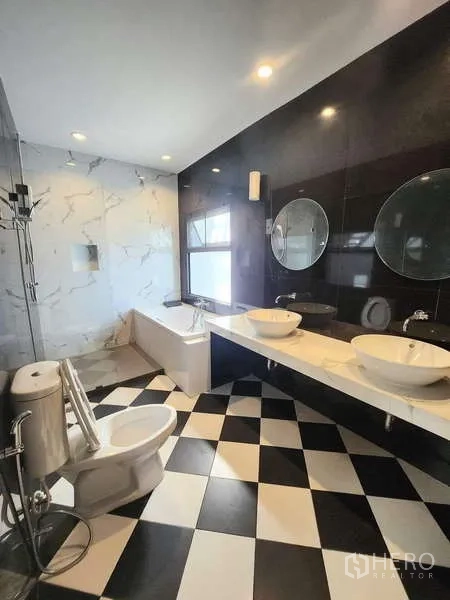 联排别墅 出租在Watthana, Bangkok - 宽敞卫浴，浴缸、双台盆与黑白棋盘格地面。