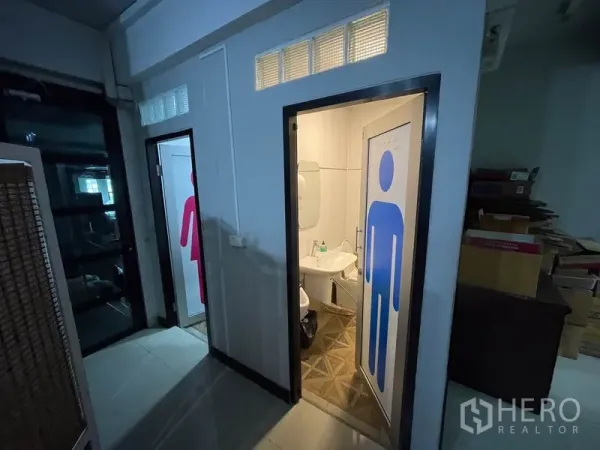 Office Space for rent in Khlong Toei, Bangkok - Corridor with clearly labeled restroom doors beside a glass entry.