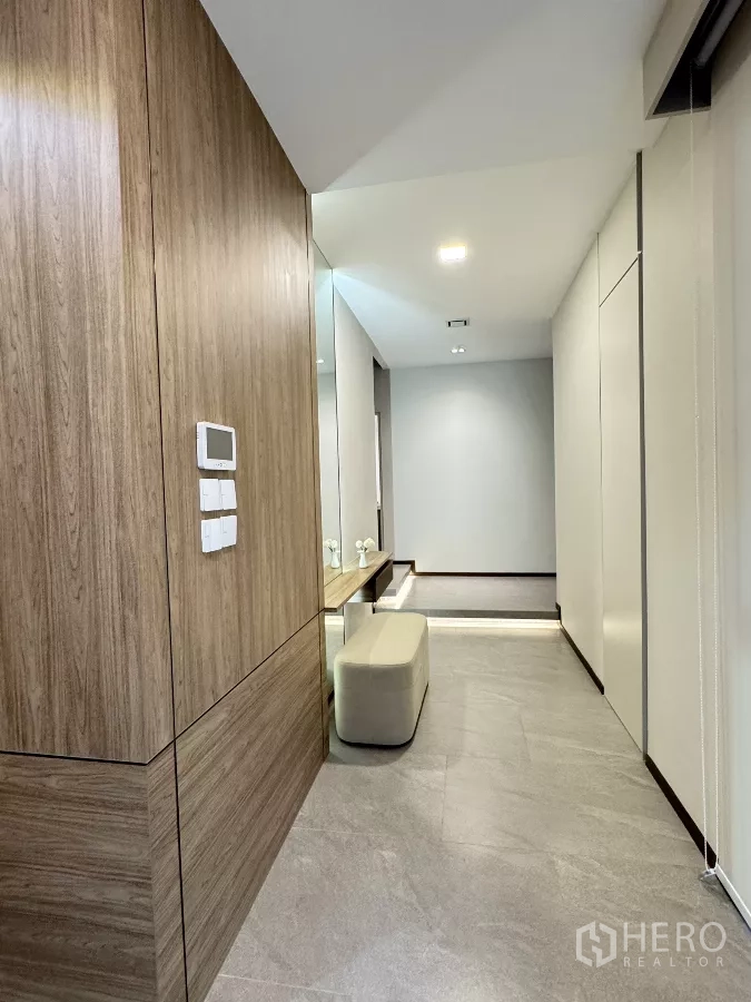 Detached House for rent in Saphan Sung, Bangkok - Hallway with wood paneling, built-in bench and wall controls.