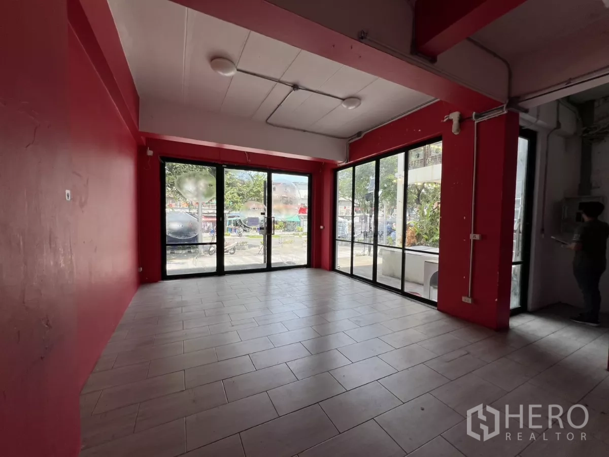 零售空间 出租在Khlong Toei, Bangkok - 转角展示区，黑框落地窗，透出街景。