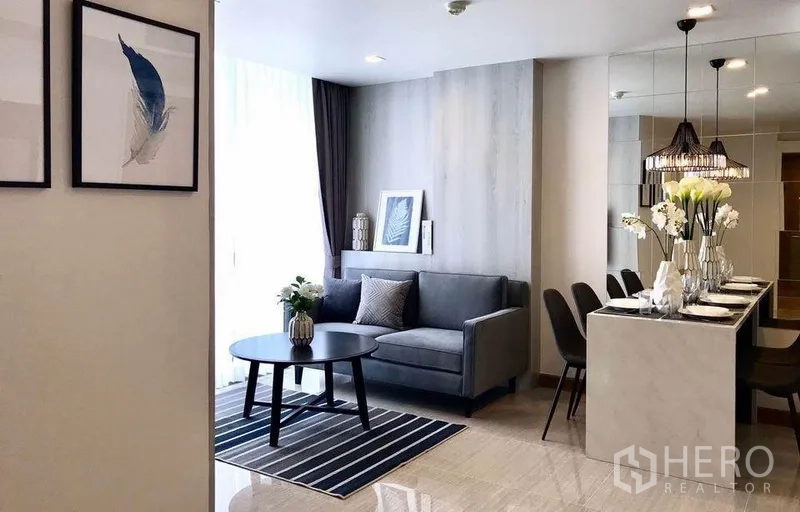 คอนโด ให้เช่าในWatthana, Bangkok - พื้นที่นั่งเล่นแบบเปิดของคอนโดวัฒนา โซฟา พรมลายทาง ไอส์แลนด์ทานอาหาร และหน้าต่างบานใหญ่เต็มผนัง