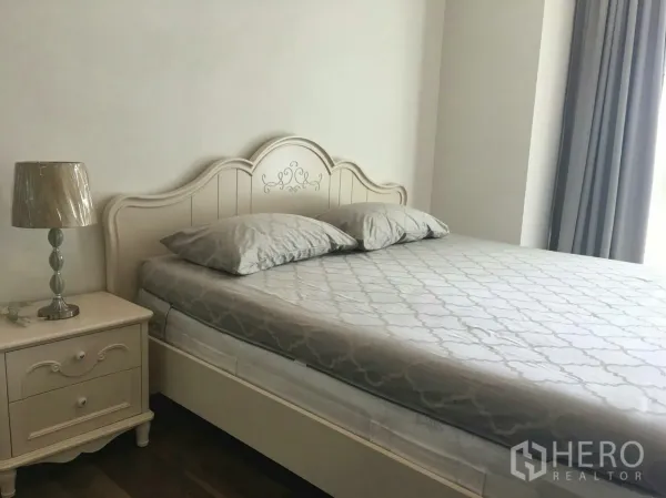 Condominium for rent in Phra Khanong, Bangkok - Cozy bedroom with a queen bed, classic headboard, bedside table and full-length curtains.