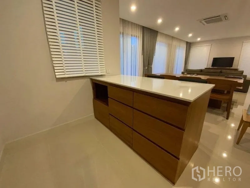 联排别墅 出租在Prawet, Bangkok - 餐区旁的木质岛台与嵌灯。