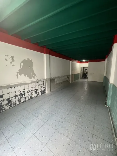 店屋 出租在Watthana, Bangkok - 一楼走廊反向视角，展示瓷砖墙面与开放式布局。