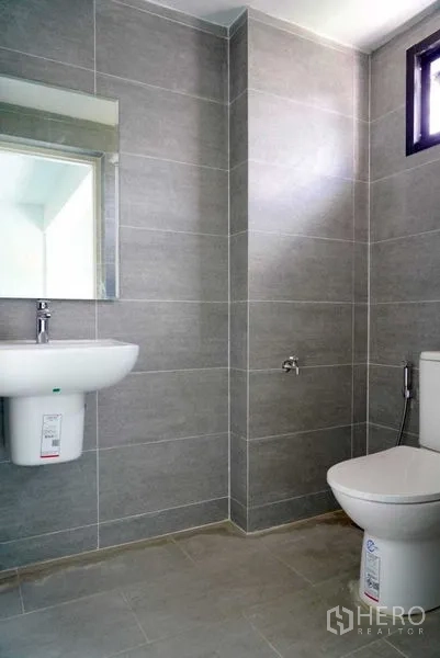 Office Space for sale in Khan Na Yao, Bangkok - Modern restroom with grey tiled walls, wall-mounted sink, and toilet.