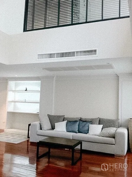 ทาวน์เฮาส์ ให้เช่าในKhlong Toei, Bangkok - ห้องนั่งเล่นเพดานสูงมีช่องกระจกชั้นลอย โซฟา และชั้นวางของบิลท์อิน