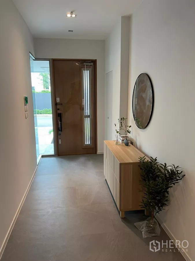 独立式住宅 出租在Saphan Sung, Bangkok - 入户走廊，木门、收纳柜与圆形壁镜。