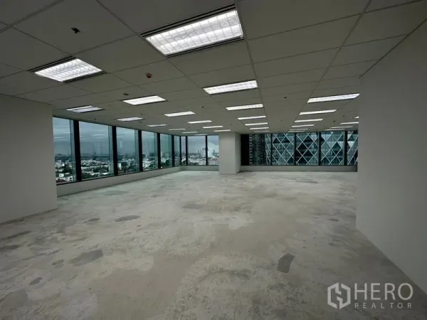 办公空间 出租在Ratchathewi, Bangkok - 250平方米开放式角落办公空间，吊顶灯具、清水地面与环幕窗，俯瞰曼谷天际线。
