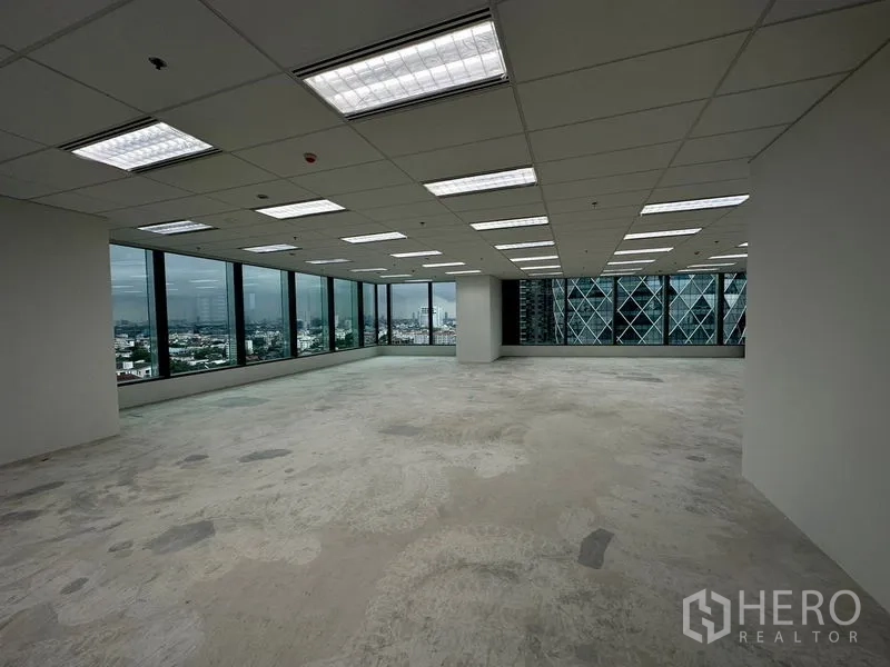 办公空间 出租在Ratchathewi, Bangkok - 250平方米开放式角落办公空间，吊顶灯具、清水地面与环幕窗，俯瞰曼谷天际线。
