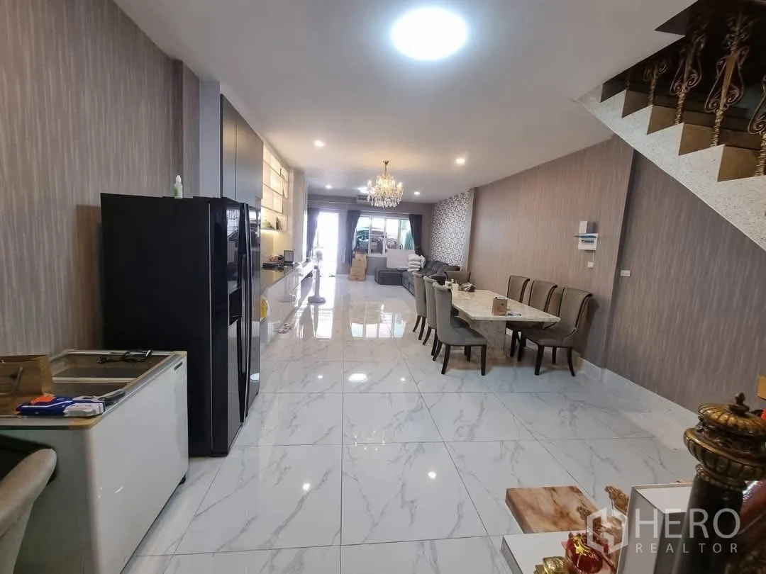 Townhouse for rent in Din Daeng, Bangkok - Wide lounge and dining zone with marble-look tiles and long TV feature wall.