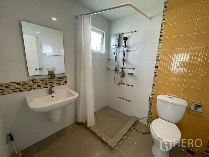 บ้าน ขายในLam Luk Ka, Pathum Thani - ห้องน้ำสว่าง โดดเด่นด้วยผนังสีเหลืองและฝักบัวพร้อมเครื่องทำน้ำอุ่น