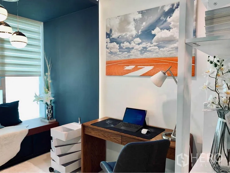 คอนโด ให้เช่าในWatthana, Bangkok - มุมทำงานสว่างโต๊ะไม้ โคมไฟตั้งโต๊ะ ผนังสีน้ำเงิน ภาพแขวน และเบาะนั่งข้างหน้าต่าง