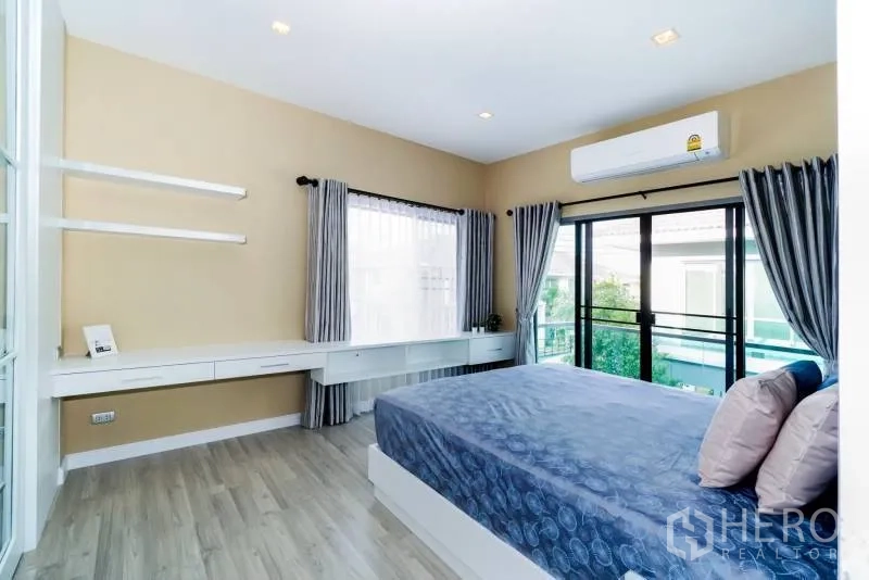 บ้าน ให้เช่าหรือขายในLat Krabang, Bangkok - ห้องนอนใหญ่ติดระเบียง หน้าต่างบานใหญ่ แอร์ และโต๊ะบิวท์อิน