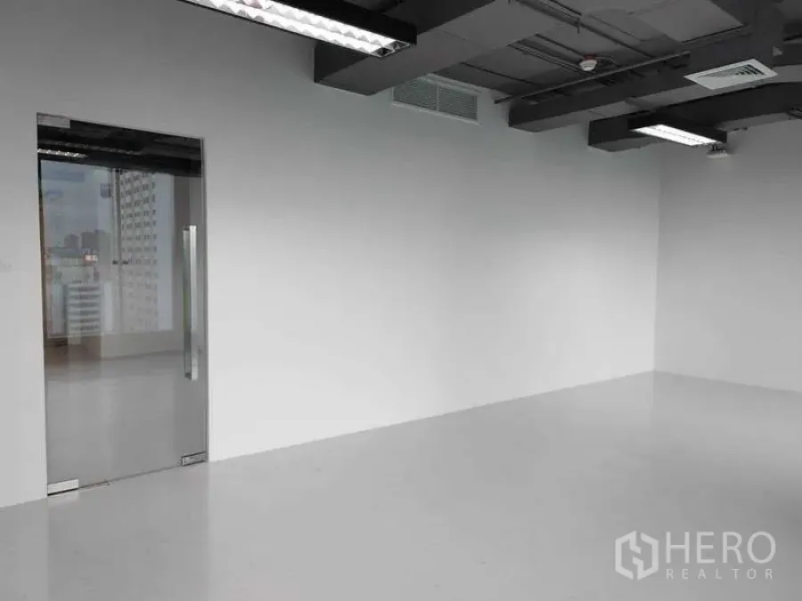 สำนักงาน ให้เช่า - ผนังมินิมอลพร้อมประตูกระจกบานเลื่อนและงานระบบเพดานเปลือย.