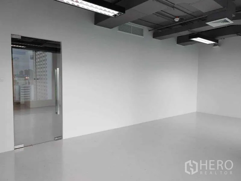 สำนักงาน ให้เช่า - ผนังมินิมอลพร้อมประตูกระจกบานเลื่อนและงานระบบเพดานเปลือย.