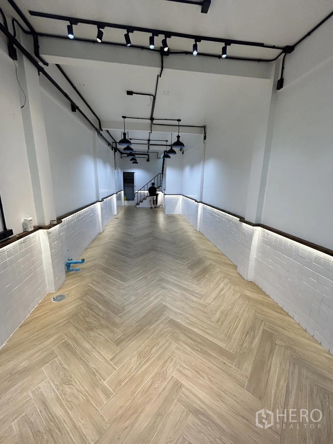 อาคารพาณิชย์ ให้เช่าในKhlong Toei, Bangkok - โถงร้านยาว พื้นลายก้างปลา ผนังกระเบื้องสีขาว ไฟราง และบันไดด้านใน