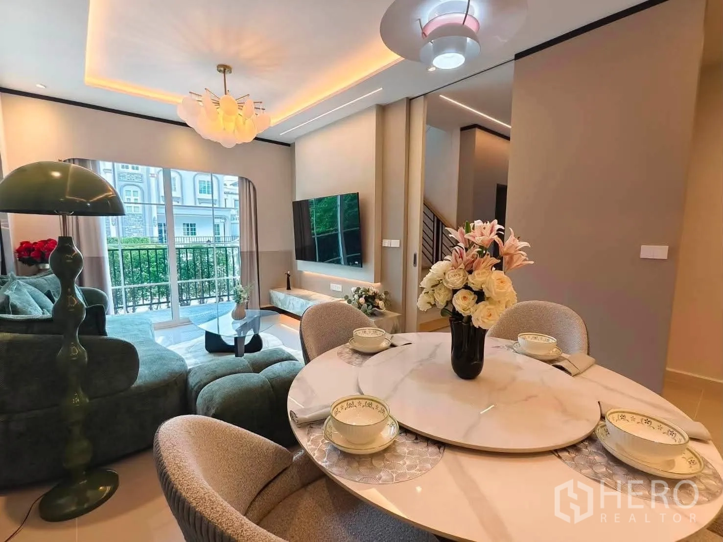 Detached House for rent in Bang Phli, Samut Prakan - Open-plan dining and living space with sofa, TV wall, and large windows.